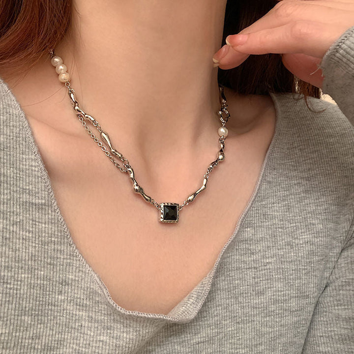 Lyra naszyjnik z czarnym kamieniem i perłą – elegancka biżuteria wyrazista