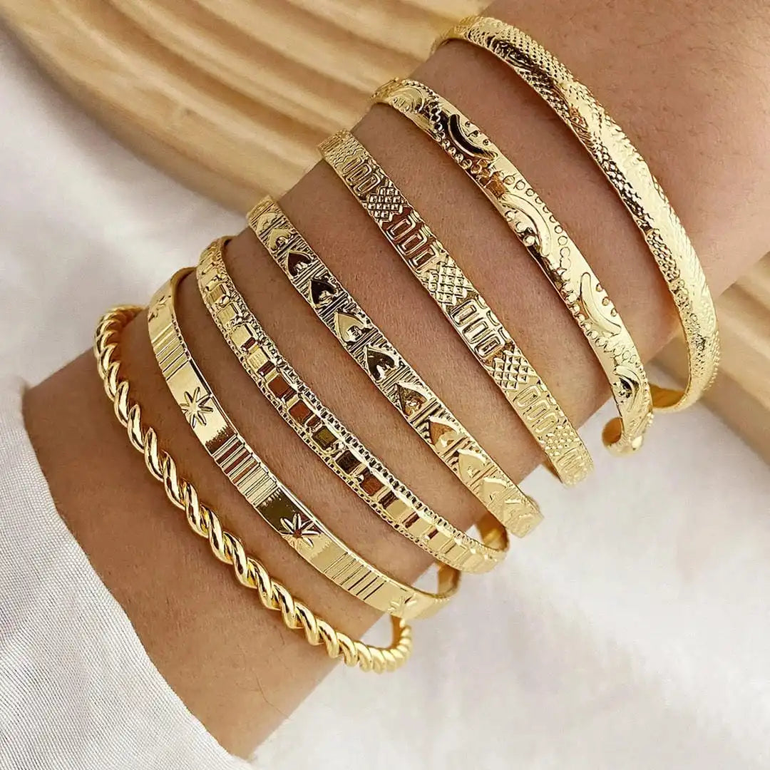 Zestaw otwartych złotych bransoletek typu bangle